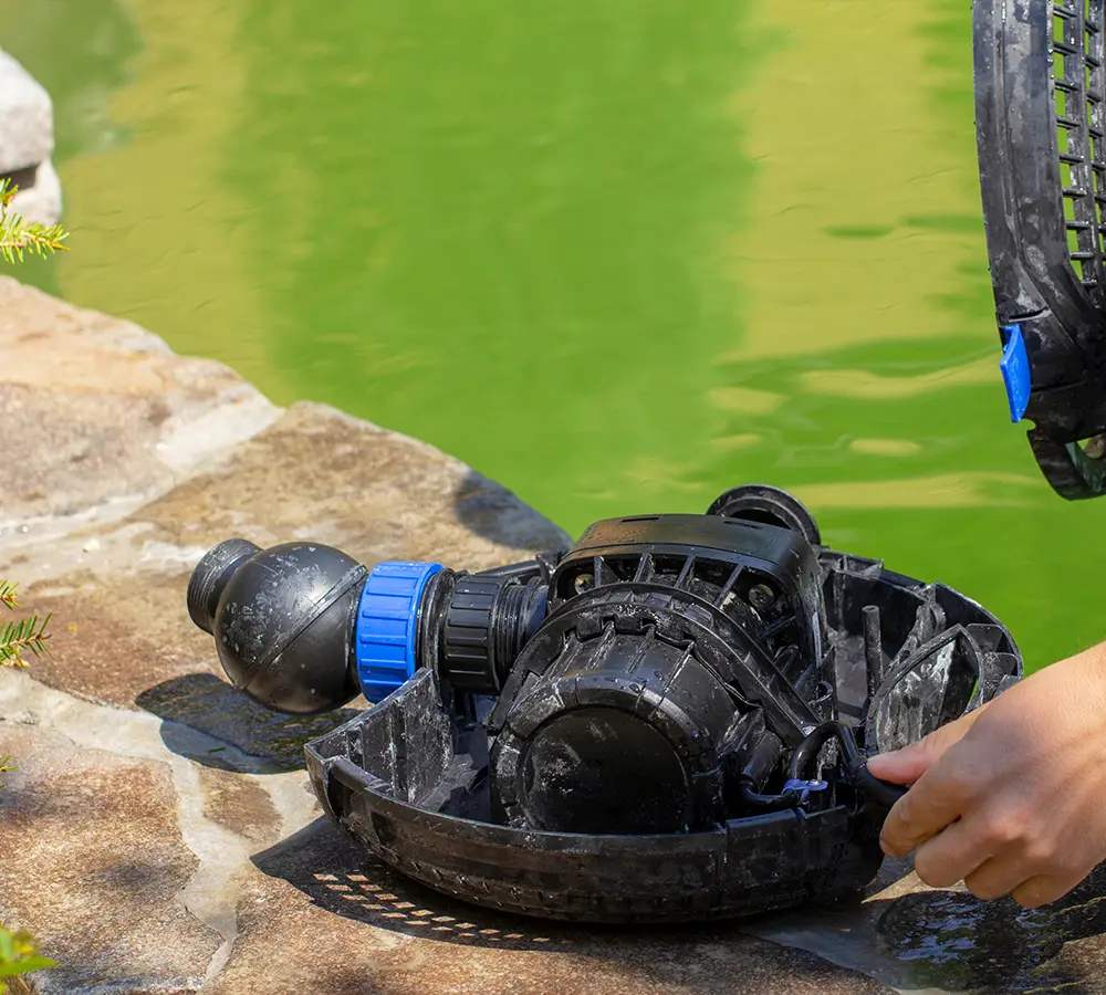 Technician repairing a pond pump to restore water flow and functionality in a backyard water feature