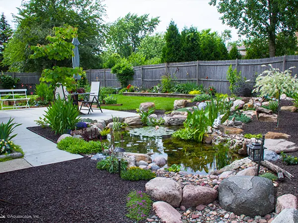 Finished backyard water feature with pond and landscaping, creating a relaxing outdoor space to enjoy nature